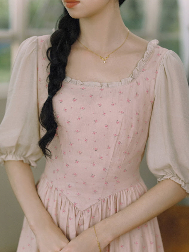 Close-up of pink cottagecore floral dress with square neckline, ruffle trim, and fitted waist