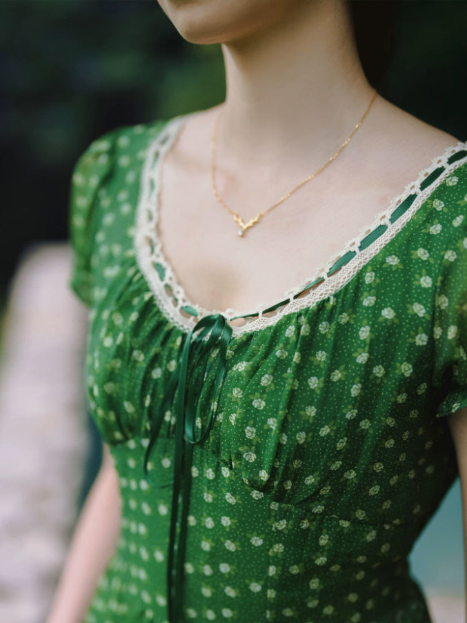 Close-up of green vintage dress with lace neckline and ribbon tie detail