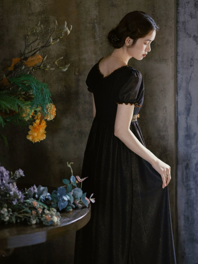 Back view of a romantic black dress with puff sleeves, square back neckline and softly flowing vintage silhouette