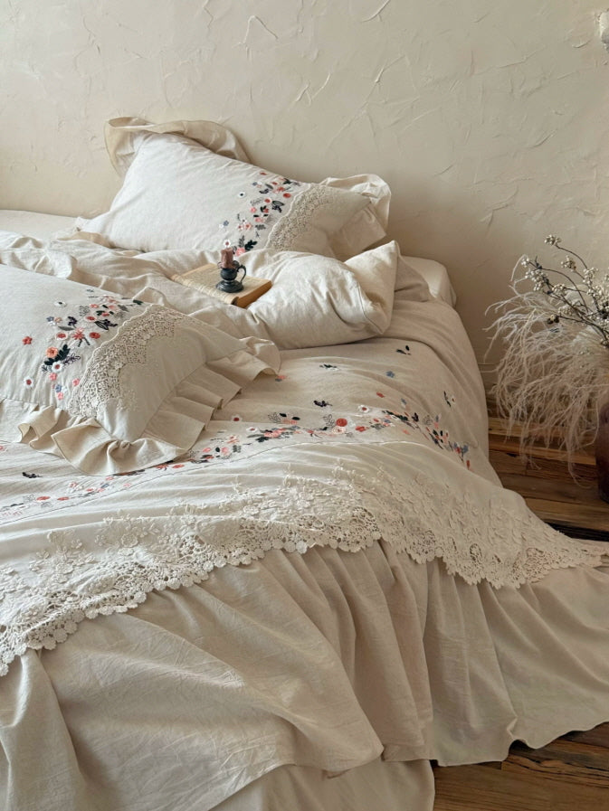 Cottagecore bedding set with delicate floral embroidery, vintage lace trim, and soft ivory ruffles in a romantic bedroom