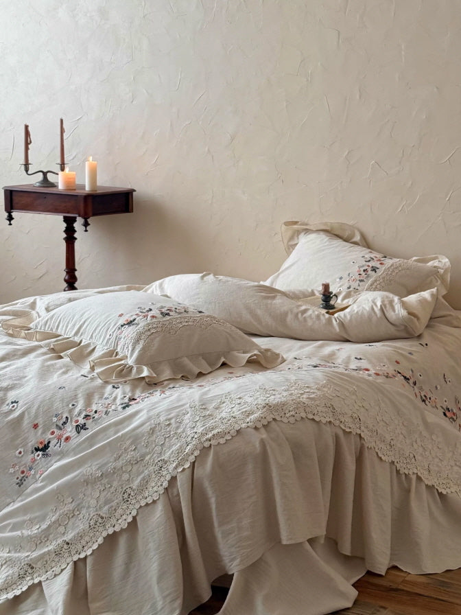 Vintage floral embroidered bedding with scalloped lace edging and ruffled pillows for a dreamy cottagecore bedroom