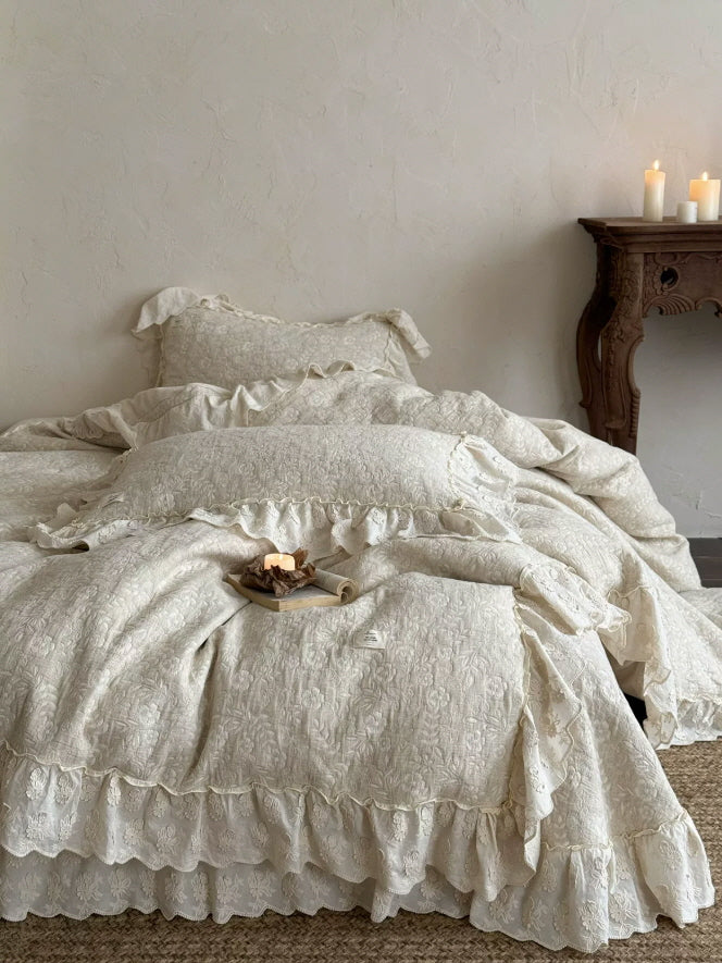 Cream embroidered flower bedding with delicate ruffled edges and vintage-inspired details