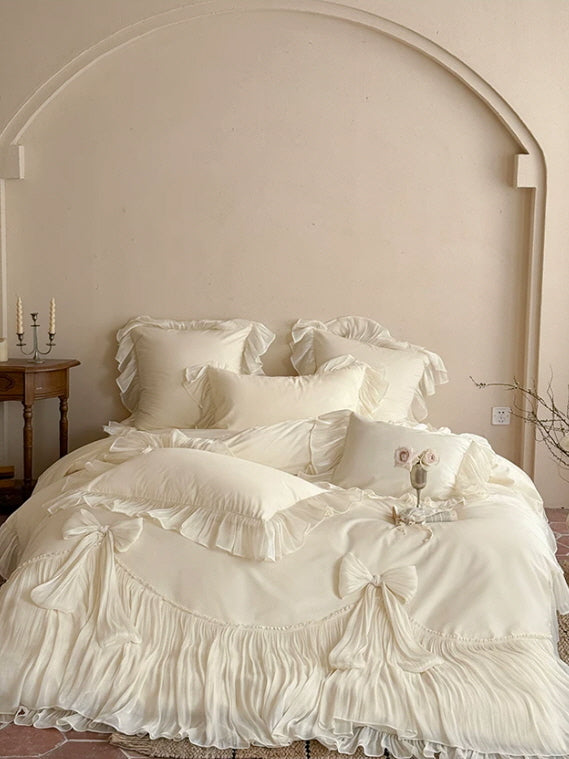Princesscore cream bedding with cascading ruffles, bow accents, and a dreamy vintage aesthetic