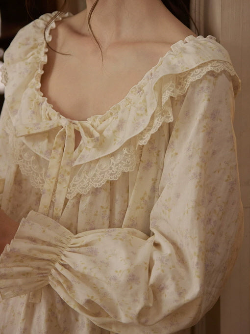 Close-up of ivory floral nightgown with layered lace ruffle neckline, bow tie and gathered long sleeves