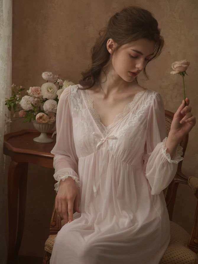 Close up of white lace nightgown with scalloped V neckline and delicate floral embroidery