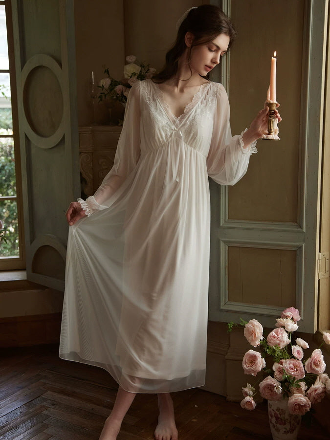 White lace nightgown with deep V neckline, sheer long sleeves and flowing romantic silhouette