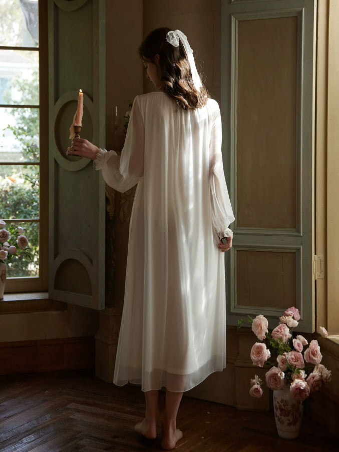 Back view of white vintage nightgown with flowing maxi length and sheer long sleeves