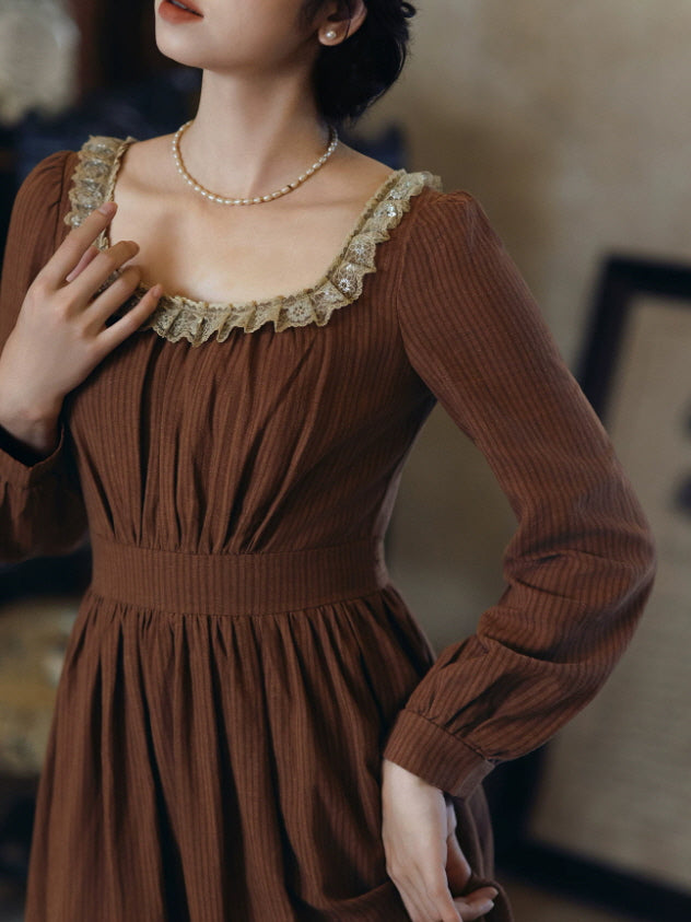Close up of brown romantic dress with beige lace neckline, fitted waist and long sleeves