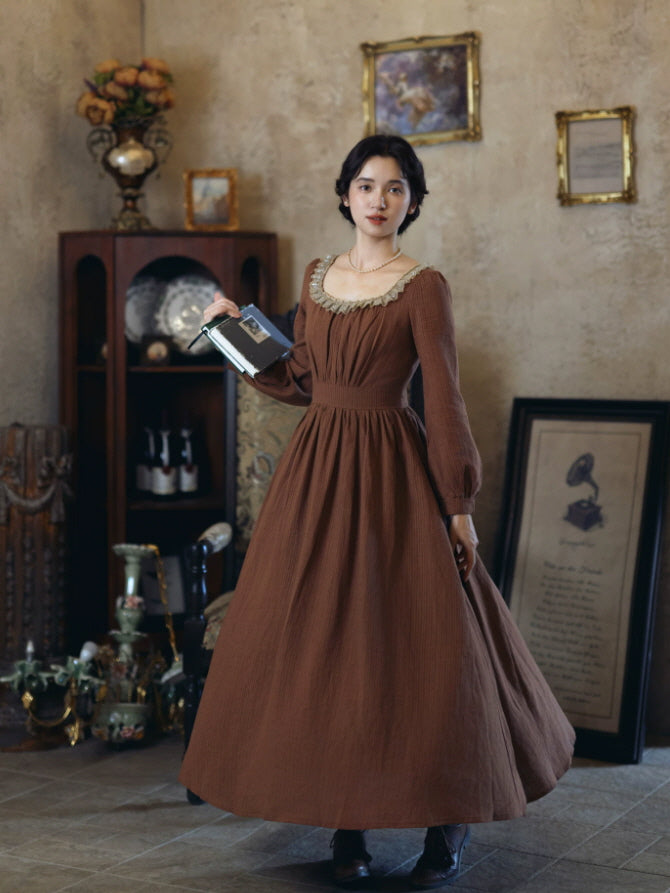 Full length brown vintage inspired dress with flowing skirt, long sleeves and square lace neckline
