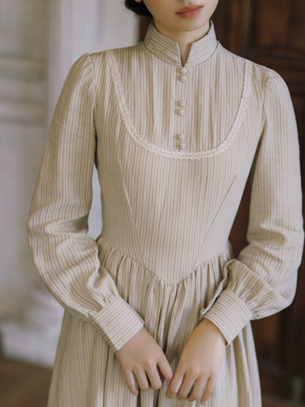Close-up of ivory vintage dress featuring high neckline, fabric-covered buttons and delicate lace trim