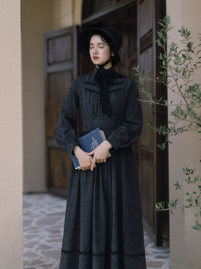 Elegant black vintage dress with high neckline, pintuck bodice and defined waist in a classic interior