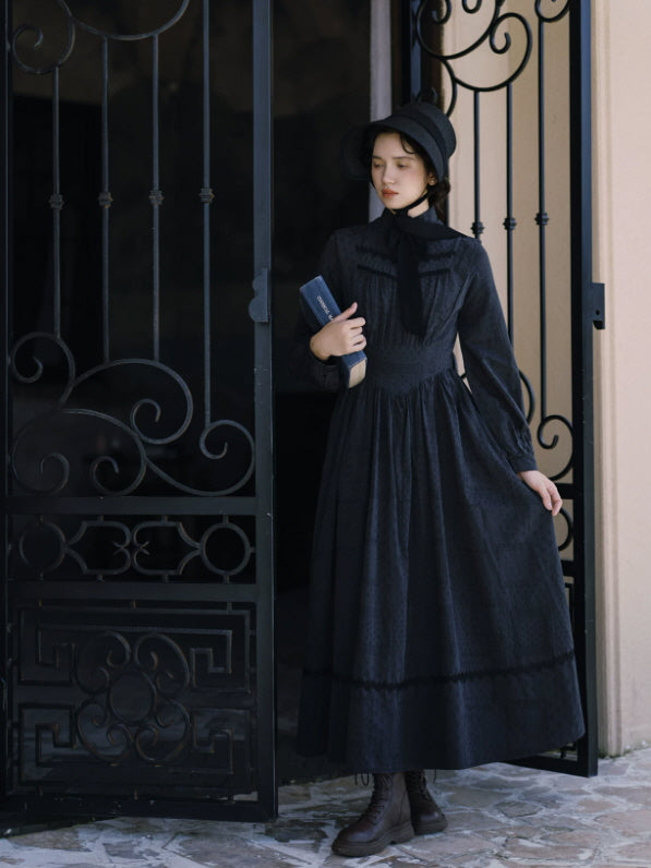 Women’s black Victorian inspired dress with high collar, fitted waist and full-length skirt