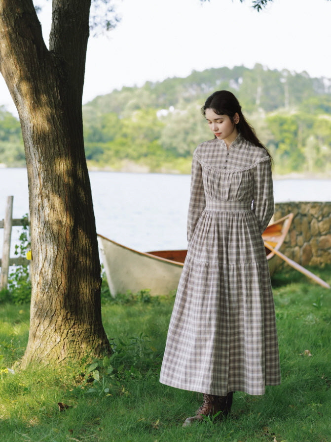 Vintage-inspired plaid dress with long sleeves, fitted waist and delicate lace trim in a garden setting
