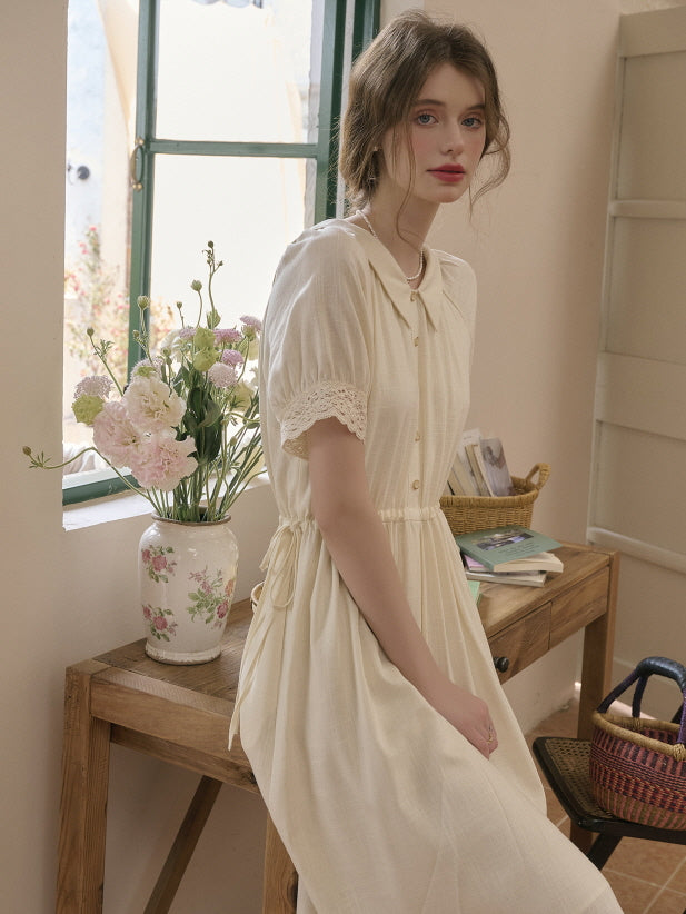 Soft vintage outfit with a delicate cream dress and lace sleeve details, styled against a cozy retro room background with flowers and natural light