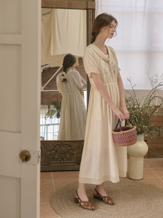 Romantic cottagecore aesthetic outfit featuring a cream vintage-style dress with lace trim, styled with a woven basket bag in a cozy indoor setting.