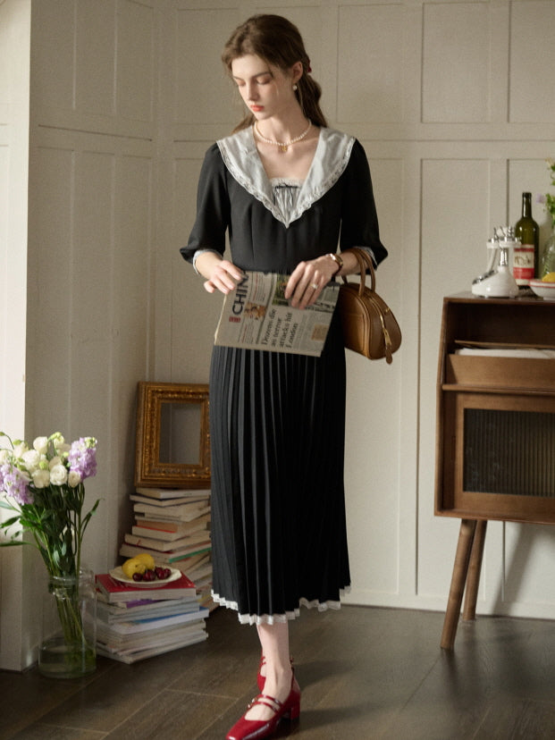 A woman in a romantic retro black dress with a wide lace-trimmed collar and pleated skirt, styled for an aesthetic and casual outfit with fairytale charm.