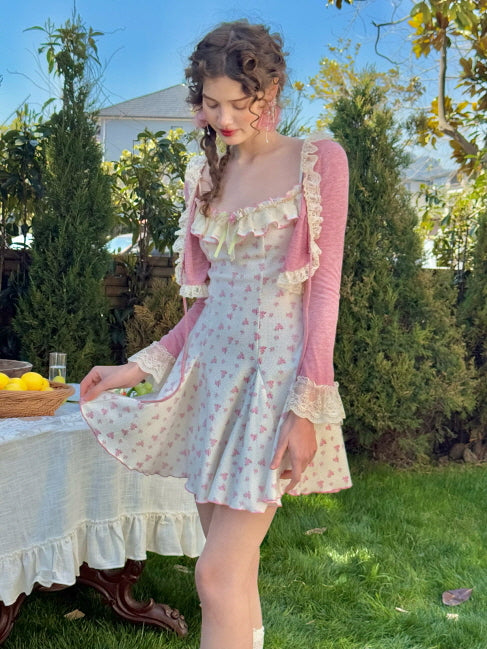 Side view of a floral knit dress with a flared hemline, styled with pastel pink ribbon detailing and ruffled lace trim for a romantic, vintage-inspired look.