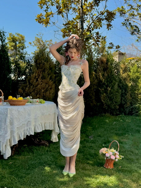 Romantic cream ruched satin midi skirt styled with floral corset top in a spring garden setting – fairytale-inspired women’s outfit with elegant silhouette