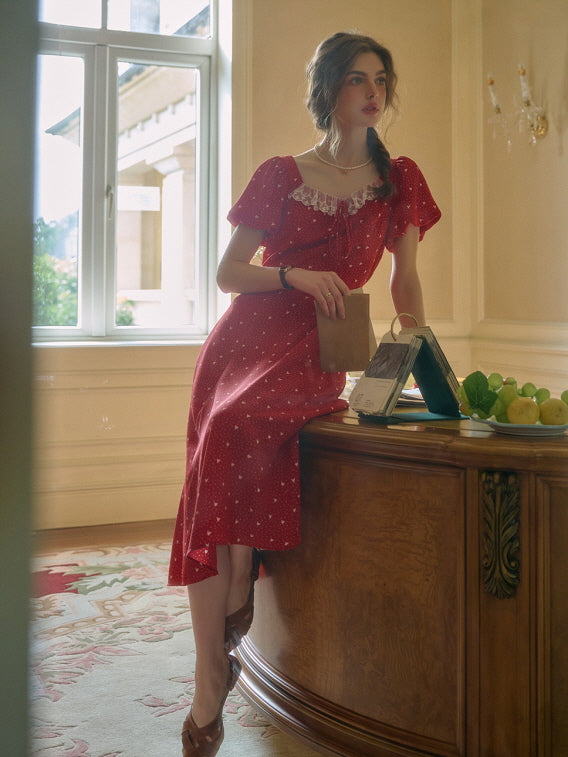 A romantic summer outfit with a red retro dress, styled casually while seated by the window in a vintage-inspired room.