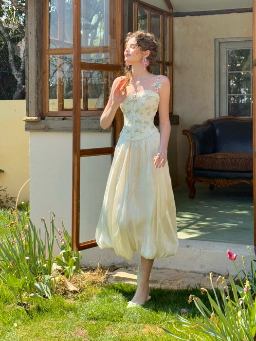 Romantic vintage cream balloon skirt with dreamy shine, styled with floral embroidery top, worn outdoors in a spring garden setting – fairycore aesthetic women's fashion