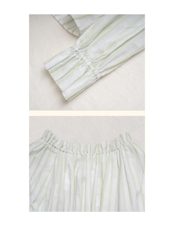 Detailed view of the sleeve cuff and elastic waistband of a light green and white striped blouse, showcasing subtle gathers and delicate stitching for a charming, fairytale-inspired look.
