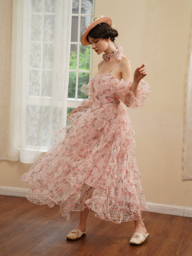 A model twirls gracefully in a layered pink flower-print chiffon dress, embodying soft elegance and fairytale charm.