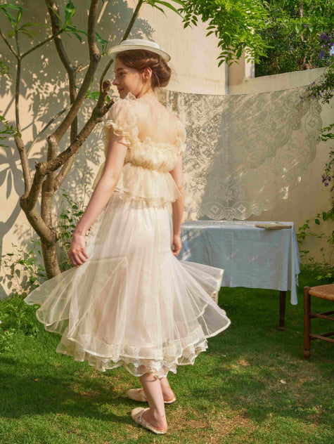 A woman spins gently in a layered lace-trimmed tulle skirt, capturing the graceful charm of a cottagecore and vintage-inspired aesthetic outfit.