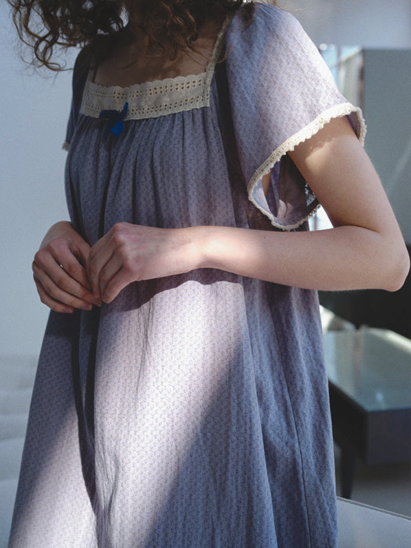Close-up of a blue cotton nightgown with flutter sleeves and delicate lace trim, styled for relaxed mornings in a fairytale-inspired silhouette.