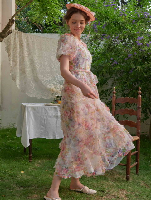 Twisting lightly in a vintage-style floral dress, the woman smiles as the soft fabric flows, capturing the dreamy essence of a cottagecore summer.