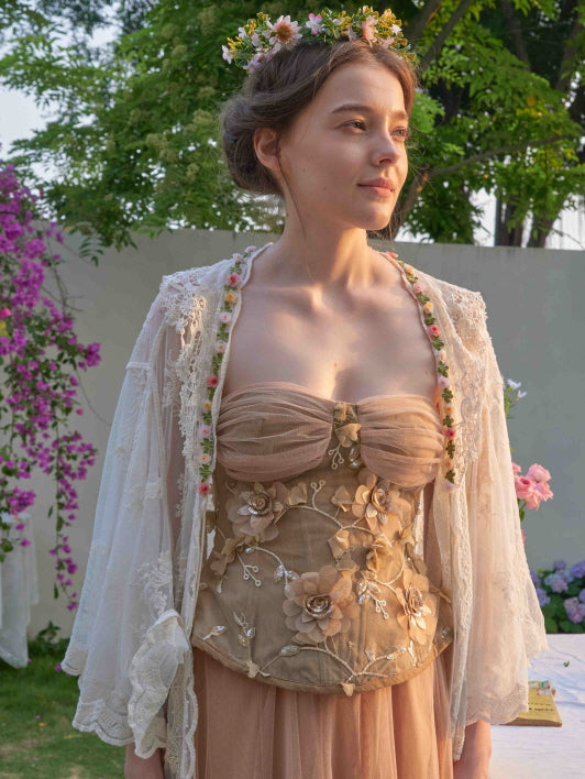 Close-up of a romantic fairycore look with a lace robe layered over a floral corset dress, completed with a whimsical flower crown.