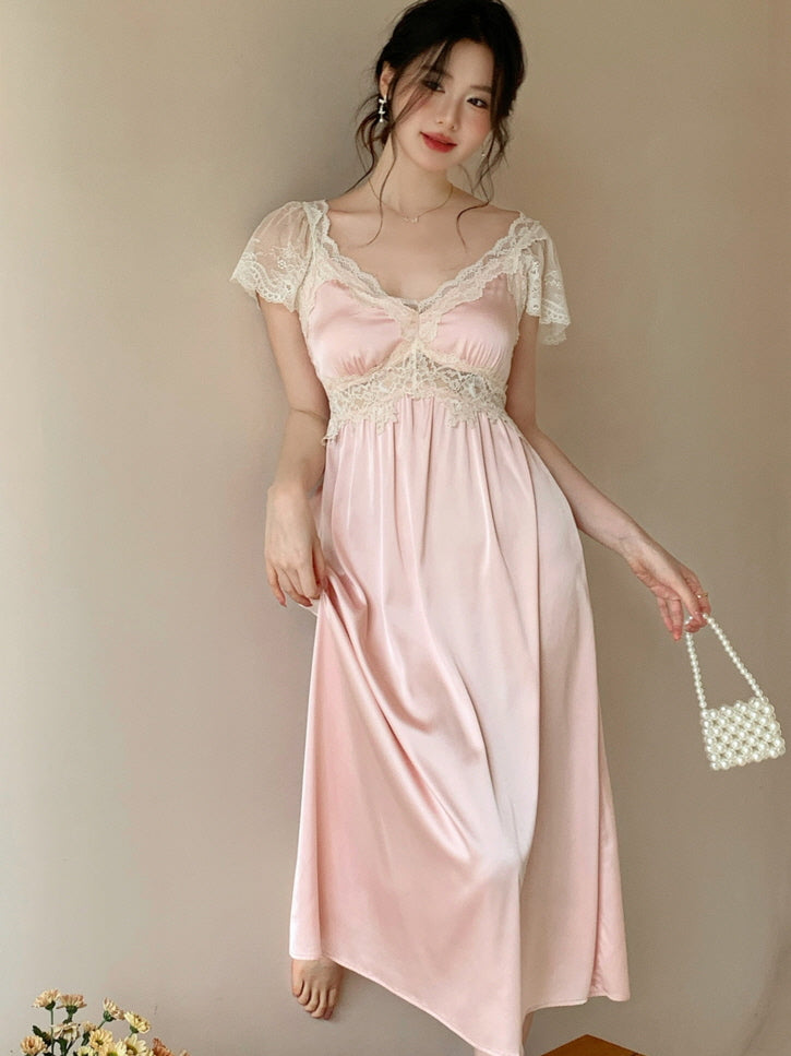 Wearing a vintage-style pink loungewear dress with lace detail, the model stands by the wall with a pearl mini bag, creating an elegant fairytale look.