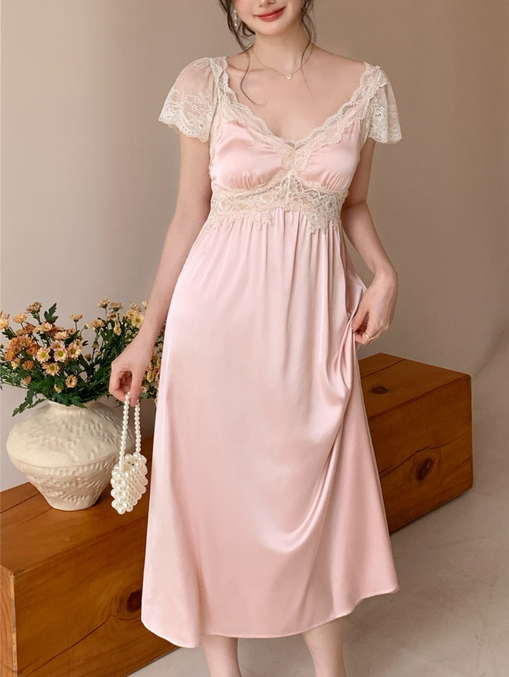 Model holding a pearl mini bag while showcasing a romantic pink nightgown with cream lace trim, embodying a dreamy fairytale look.