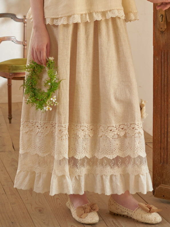 Detailed view of a romantic beige skirt with scalloped lace panels and sheer embroidery, paired with ribbon-accented crochet flats.