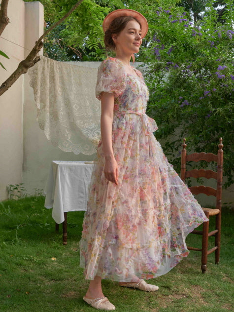Walking through the garden in a ruffled floral gown, the woman exudes vintage charm and fairycore grace with every soft, flowing step.