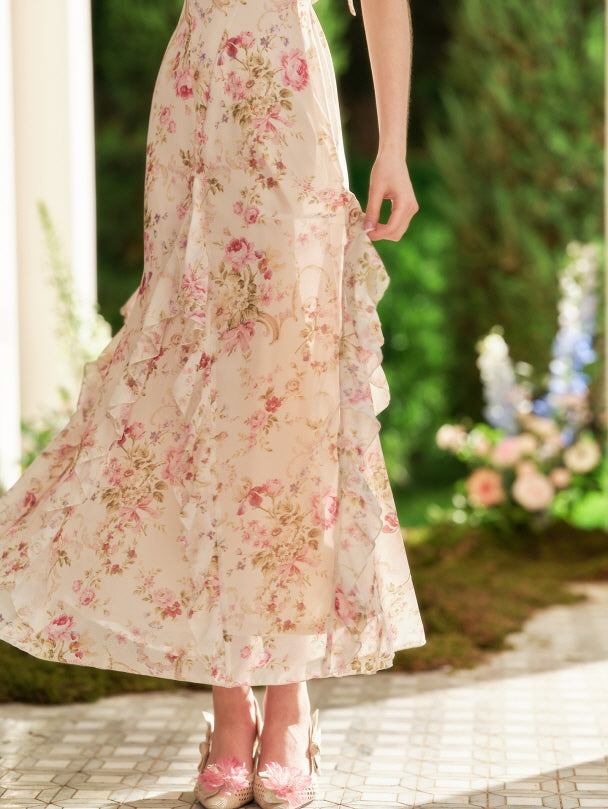 The soft ruffles of a vintage floral dress flow gently as the model lifts the hem, showcasing the romantic print and delicate movement.