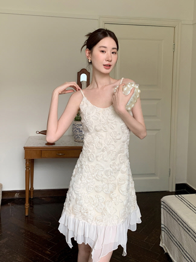 A woman poses in a textured floral mini dress with an airy layered hem, holding a pearl bag that adds a coquette and vintage-inspired charm.