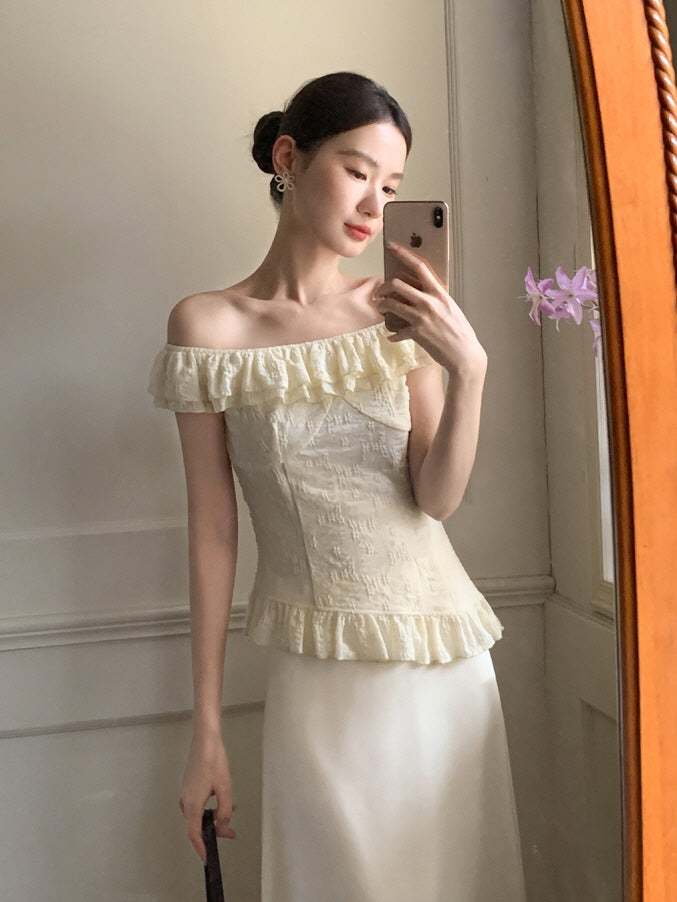 Mirror selfie of a woman in a soft ivory fairycore blouse with textured ruffles and a flowy skirt, styled in a light-filled vintage room.