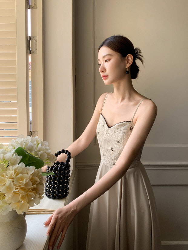 Looking out the window with gentle light on her face, a woman wears a vintage-inspired embroidered dress, evoking a calm romantic atmosphere.