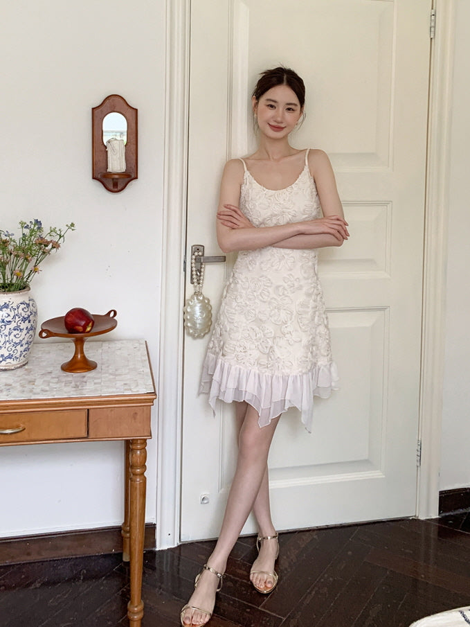 Smiling by a vintage door, she poses in a fairytale-inspired cream dress adorned with 3D floral details and a flowy ruffled hem.