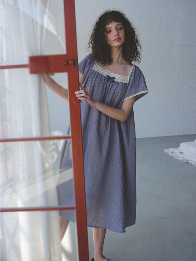 A close-up of the lavender nightgown hem in soft morning light, styled with blue plaid slippers for a relaxed vintage cottagecore moment.