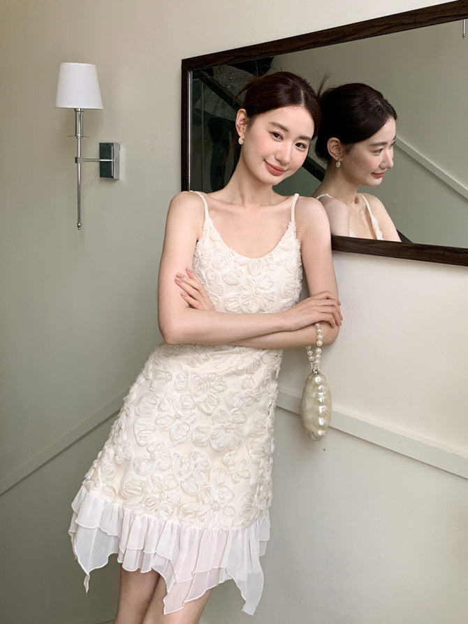 She smiles in front of a mirror wearing a delicate flower-appliqué dress with a layered chiffon hem, holding a pearl bag in a fairycore look.