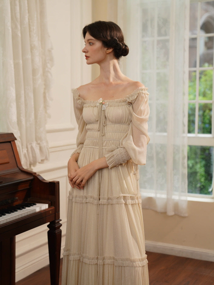 Standing serenely in a soft cream dress with ruched bodice and puff sleeves, the model evokes a quiet fairytale grace near the piano.