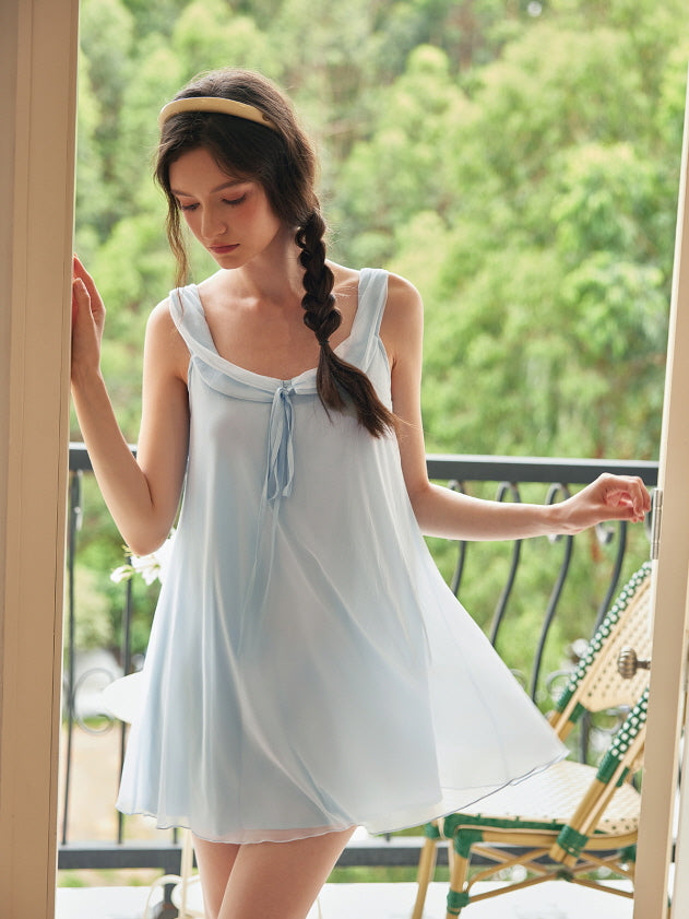 Stepping out onto the balcony in a pastel blue loungewear dress, the model brings a light and airy fairycore vibe to a serene morning scene.