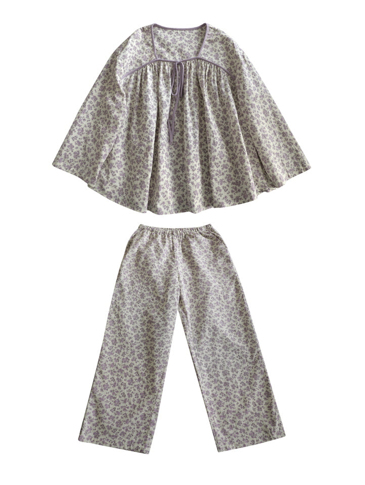 Flat lay of a lavender floral pajama set with a ribbon tie top and wide-leg pants, offering a cozy vintage-inspired loungewear look with cottagecore charm.