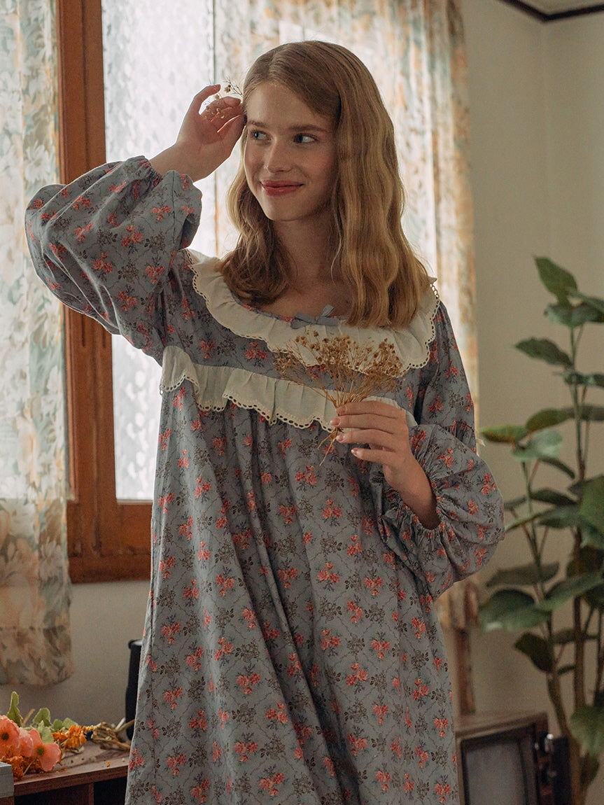 A dreamy moment in a blue floral nightgown with lace ruffle detailing, evoking a vintage fairytale vibe with cottagecore charm.