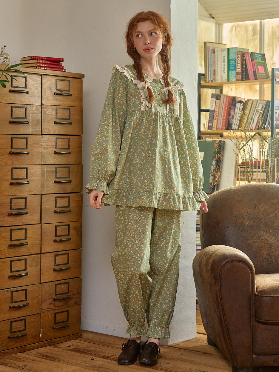 A cozy, vintage-inspired green floral loungewear set with lace-trimmed collar and ruffled cuffs, styled with cottagecore charm in a warm, rustic setting.