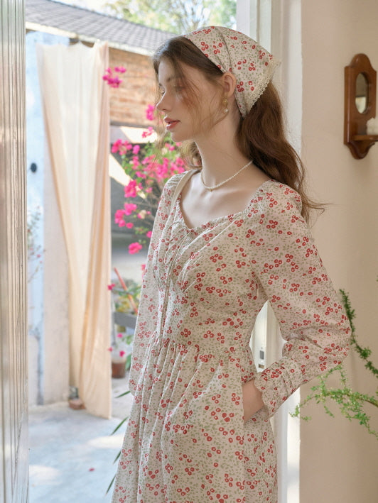side view of woman in a floral retro cottagecore dress with pockets, matching headscarf, and a soft natural background