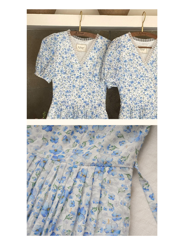Two blue floral print dresses with a vintage-inspired V-neckline and gathered waist hanging side by side. The soft floral pattern exudes a romantic, cottagecore aesthetic.