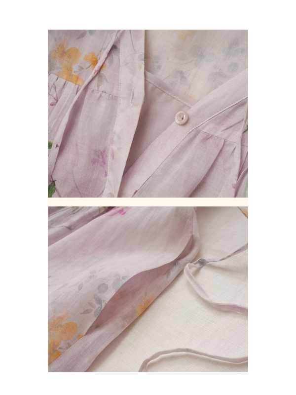 A back view of the pastel lilac floral dress showcasing the gathered pleats at the shoulders and the lace-trimmed puff sleeves. The dress exudes a dreamy, vintage-inspired aesthetic with its soft floral print and airy, flowy silhouette.