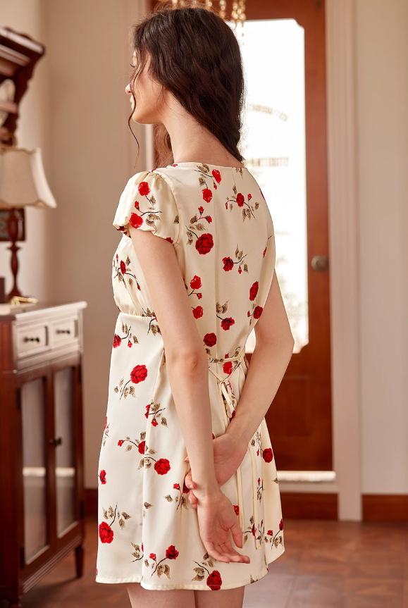 The model stands gracefully in a cream vintage-style night dress with red rose prints and puff sleeves, radiating soft cottagecore elegance.
